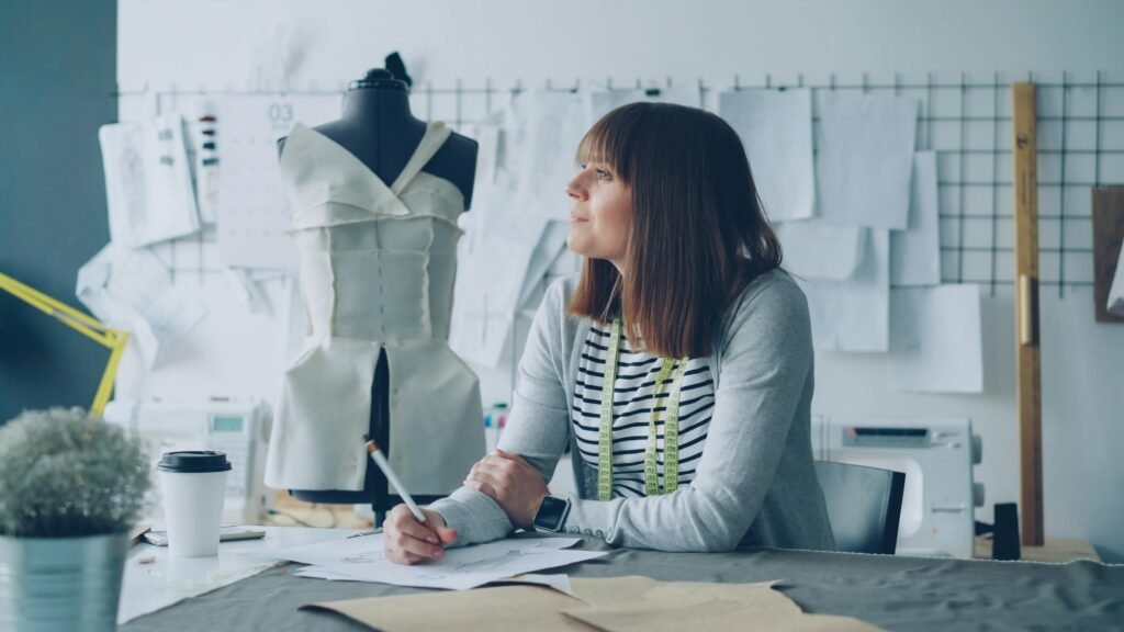 A fashion designer plans new creations in a modern studio setting.