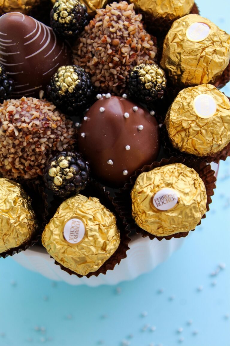 Top view of assorted chocolate truffles and Ferrero Rocher on a light blue background, perfect for dessert presentations.