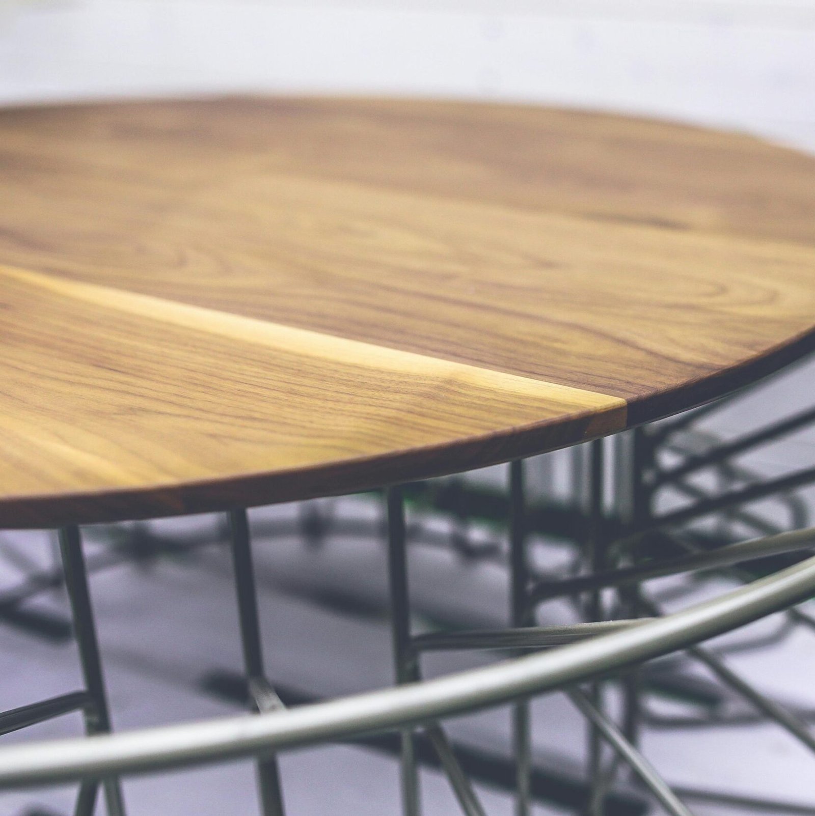 Stylish round wooden table with metal frame, perfect for modern outdoor spaces.